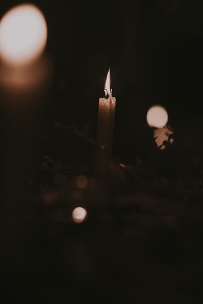 点燃的蜡烛在黑暗的房间里散景摄影
